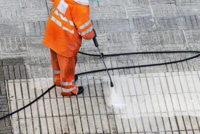 Employé du Groupe SATURNE qui procède à un nettoyage haute pression sur des dalles en béton