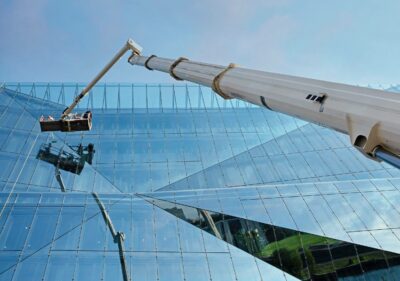 Groupe Saturne - Des employés nettoient les vitres d'un immeuble à l'aide d'une grue nacelle